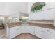 Bright kitchen with white cabinets, ample counter space, and view to a breakfast nook at 48 Par View Ct, Rotonda West, FL 33947