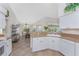 Open-concept kitchen featuring white cabinetry, tile flooring, and a view into the dining area at 48 Par View Ct, Rotonda West, FL 33947