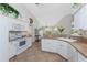 Bright kitchen with white cabinetry, modern appliances, and an open layout leading to the dining area at 48 Par View Ct, Rotonda West, FL 33947