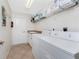 Functional laundry room with a washer, dryer, utility sink, and ample shelving for storage at 48 Par View Ct, Rotonda West, FL 33947