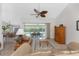 Cozy living room featuring tile flooring, ceiling fan, and sliding doors to the screened-in lanai at 48 Par View Ct, Rotonda West, FL 33947