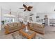 Inviting living room featuring tile flooring, ceiling fan, and a view of the dining room and kitchen at 48 Par View Ct, Rotonda West, FL 33947