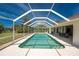 A serene screened-in pool is surrounded by lush greenery, providing privacy and shade for relaxation at 48 Par View Ct, Rotonda West, FL 33947