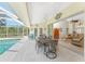 Outdoor dining table is steps away from the living room and pool with a screened-in enclosure and ceiling fan at 48 Par View Ct, Rotonda West, FL 33947