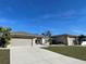 Charming single-story home with a well-manicured lawn, beige exterior, and attached two-car garage at 5262 Weatherton St, North Port, FL 34288