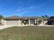 Charming single-story home with a well-manicured lawn, beige exterior, and screened front entry at 5262 Weatherton St, North Port, FL 34288