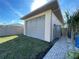 A detached two-car garage with side service door, beige exterior and a brick paver walkway at 5262 Weatherton St, North Port, FL 34288