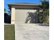 A detached two-car garage with a beige exterior, concrete driveway, and manicured lawn at 5262 Weatherton St, North Port, FL 34288