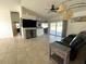Spacious living room with neutral tile, fan, modern lighting, and sliding doors to the pool at 5262 Weatherton St, North Port, FL 34288