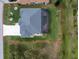 Aerial view of a property with a pool, gray roof, green lawn, and an extended driveway at 59 Long Meadow Ln, Rotonda West, FL 33947