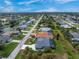 Neighborhood view of home near canals, mature trees, and lush landscaping at 59 Long Meadow Ln, Rotonda West, FL 33947