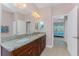 Bathroom with granite countertops, double sinks, and a view into the bedroom at 59 Long Meadow Ln, Rotonda West, FL 33947