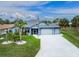 Charming single-story home with well-manicured lawn, palm trees, and a spacious three-car garage at 59 Long Meadow Ln, Rotonda West, FL 33947