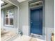 Close-up of the elegant blue front door complemented by manicured landscaping and a sidelight window at 59 Long Meadow Ln, Rotonda West, FL 33947