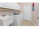 Laundry room featuring white cabinets, laundry sink, washer and dryer, and tile flooring at 59 Long Meadow Ln, Rotonda West, FL 33947