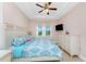 Cozy main bedroom featuring a ceiling fan, dresser, and a large window providing lots of natural light at 59 Long Meadow Ln, Rotonda West, FL 33947
