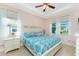 Comfortable main bedroom with a queen-size bed, ceiling fan, and natural light from the windows at 59 Long Meadow Ln, Rotonda West, FL 33947