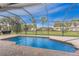 Inviting screened-in pool area featuring brick pavers and lush landscaping, perfect for relaxation at 59 Long Meadow Ln, Rotonda West, FL 33947