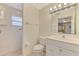 Bathroom featuring white tiled shower, toilet, and vanity with ample lighting at 7151 Cork Ln, Englewood, FL 34224