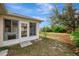 Exterior view of the home showcasing the lanai with access to the backyard and the adjacent screened pool enclosure at 7151 Cork Ln, Englewood, FL 34224