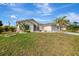 Well-maintained single-story home featuring a two-car garage and landscaped front yard at 7151 Cork Ln, Englewood, FL 34224