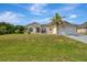 Charming single-story home with a well-manicured lawn and a mature palm tree in the front yard at 7151 Cork Ln, Englewood, FL 34224