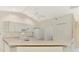 Clean kitchen features white cabinets, modern appliances, and a breakfast bar overlooking the living area at 7151 Cork Ln, Englewood, FL 34224