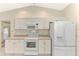Bright kitchen features white cabinets, countertops, appliances, and tile flooring at 7151 Cork Ln, Englewood, FL 34224