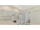 Open kitchen with white cabinetry, modern appliances, and a breakfast bar connecting to the living area at 7151 Cork Ln, Englewood, FL 34224