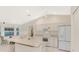 Well-lit kitchen features white cabinets, modern appliances, and a convenient breakfast bar at 7151 Cork Ln, Englewood, FL 34224