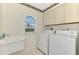 The laundry room features a utility sink and a washer and dryer at 7151 Cork Ln, Englewood, FL 34224