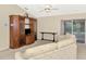 Cozy living room features a ceiling fan, entertainment center, and sliding glass doors to the lanai at 7151 Cork Ln, Englewood, FL 34224