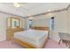 Main bedroom with carpet, tray ceilings, natural light, and light wood furniture at 7151 Cork Ln, Englewood, FL 34224