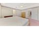 Carpeted main bedroom with ceiling fan, dresser, and access to ensuite bathroom at 7151 Cork Ln, Englewood, FL 34224