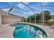 Beautiful kidney-shaped pool inside a screened enclosure provides a private oasis for outdoor enjoyment at 7151 Cork Ln, Englewood, FL 34224
