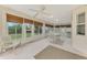 This sunroom features white floors, glass windows, and a ceiling fan at 7151 Cork Ln, Englewood, FL 34224