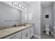 Bright bathroom featuring a granite countertop, a well-lit mirror, and white cabinets at 7499 Ashtabula St, Englewood, FL 34224