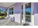 Charming front porch showcasing a cozy seating area with a decorative glass front door and white trim at 7499 Ashtabula St, Englewood, FL 34224