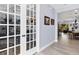 Elegant hallway with light wood floors and French doors leading to a stylish room with decorative furnishings at 7499 Ashtabula St, Englewood, FL 34224