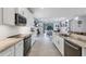 Bright kitchen with stone countertops, white cabinets, and stainless steel appliances at 7499 Ashtabula St, Englewood, FL 34224