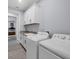 Efficient laundry room with a sink, modern washer and dryer, and clean white cabinetry at 7499 Ashtabula St, Englewood, FL 34224