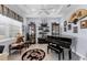 Sophisticated living room featuring a piano, display cabinets, and a unique dragon-themed rug on wood floors at 7499 Ashtabula St, Englewood, FL 34224