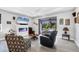Bright living room with a modern fireplace, large TV, and comfortable seating, leading to an outdoor patio at 7499 Ashtabula St, Englewood, FL 34224
