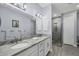 Main bathroom with double sink vanity and walk-in shower with glass door at 7499 Ashtabula St, Englewood, FL 34224