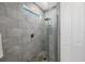 Tiled walk-in shower featuring a glass enclosure, rain shower head, and pebble floor at 7499 Ashtabula St, Englewood, FL 34224