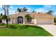 Lovely residence showcasing a well-kept lawn, classic architectural details, and an attached two-car garage at 816 Rotonda Cir, Rotonda West, FL 33947