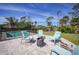 Backyard patio with stone pavers, chairs, and a fire pit near the pool at 8164 Archie St, Englewood, FL 34224