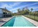 Outdoor pool with safety fencing and hot tub offers a secure and relaxing backyard retreat at 8164 Archie St, Englewood, FL 34224