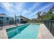 Backyard pool with brick pavers, safety fence, and tropical landscaping at 8164 Archie St, Englewood, FL 34224
