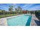 Relaxing in-ground pool with brick pavers, complemented by a black fence and lush greenery at 8164 Archie St, Englewood, FL 34224